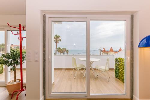 a sliding glass door leading to a dining room with a table at RENT4REST Estoril Seafront Apartments in Estoril