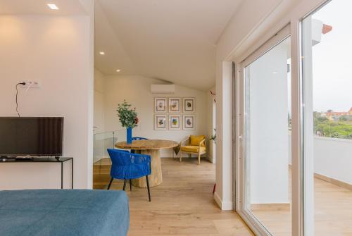 a room with a bed and a table and chairs at RENT4REST Estoril Seafront Apartments in Estoril