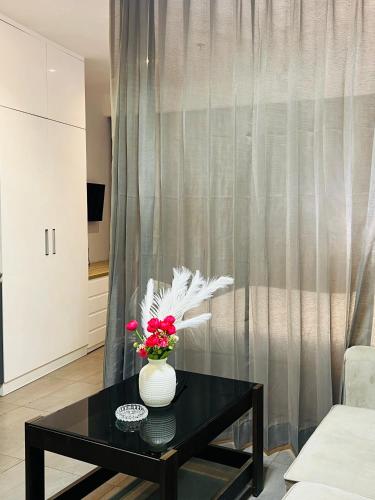 a vase with flowers on a table in a living room at Spira Supernova in New Delhi