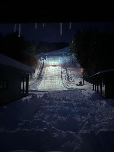 a snow covered road at night with a light on at Horský Hotel Podjavorník in Papradno