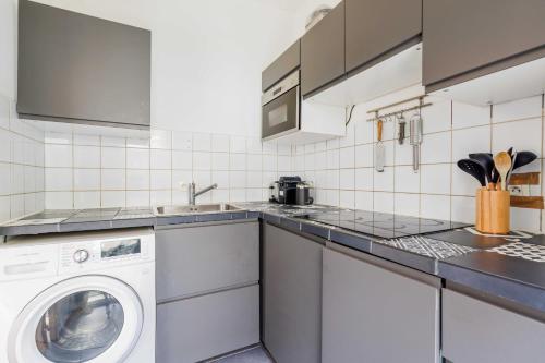 une cuisine avec une machine à laver et un lave-linge dans l'établissement Classy appartement - Clichy, à Clichy