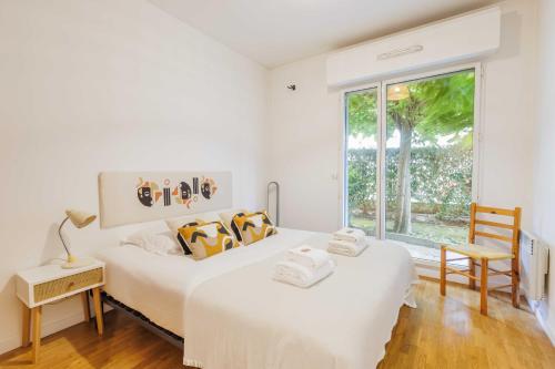 deux lits dans une chambre blanche avec une fenêtre dans l'établissement Classy appartement - Clichy, à Clichy