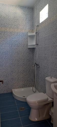 a bathroom with a toilet and a tub and a sink at Keramos in Loutro