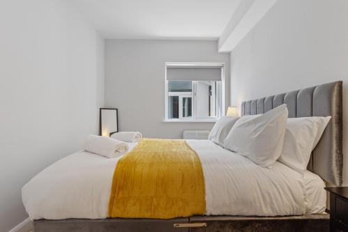 a bedroom with a bed with a yellow blanket on it at Modern Apartment Free Off Road Parking 2x Double Rooms Suite 11 in Nottingham