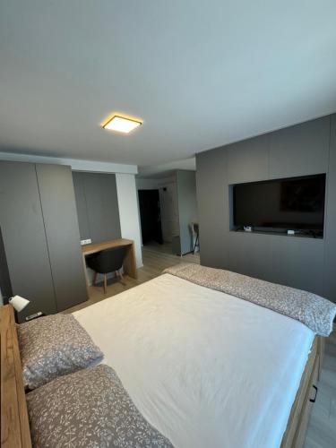 a bedroom with a large white bed and a desk at Central suites in Drobeta-Turnu Severin