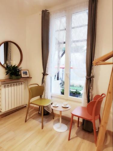 un salon avec une table et des chaises et une fenêtre dans l'établissement Madame paris, à Villejuif
