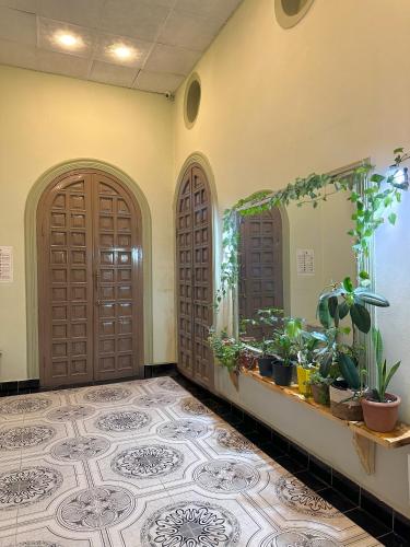 a hallway with two doors and a tiled floor at Flora Music & Art Hostel in Baku
