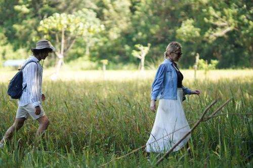 a man and a woman walking through a field at Treehouse Chalets - Luxury getaway within a short distance of Ella in Belihul Oya