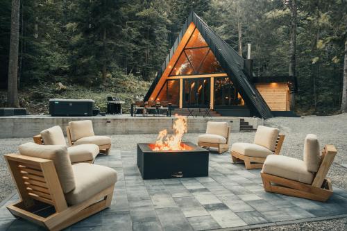 a fire pit in front of a log cabin at The Cozy Chalet in Bosanski Petrovac