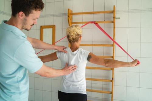 a man standing next to a woman with a red tape at Haus am Kurpark in Bad Birnbach