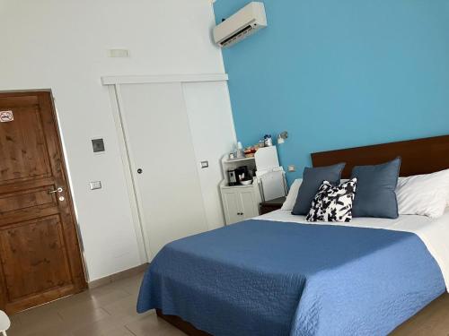 a bedroom with a bed with a blue wall at Jonio B&B in Acireale