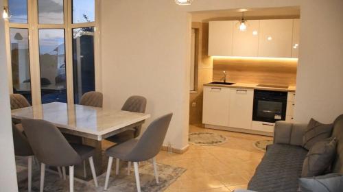 une cuisine et une salle à manger avec une table et des chaises dans l'établissement Apartment Germia, à Pristina