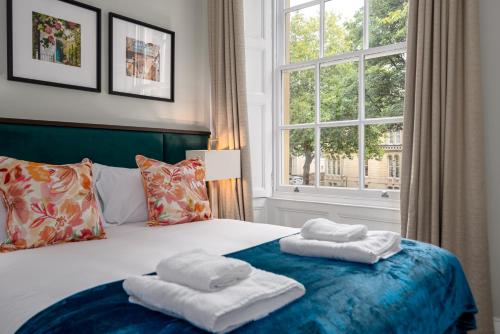 a bedroom with two towels on a bed with a window at Redmayne House - Urban Apartments in Bristol