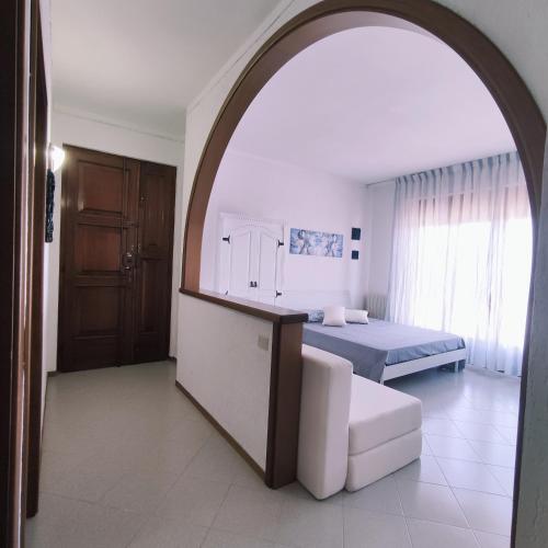 a bedroom with a bed and a chair and an archway at Appartamento Tuttiventi in Campiglia Marittima