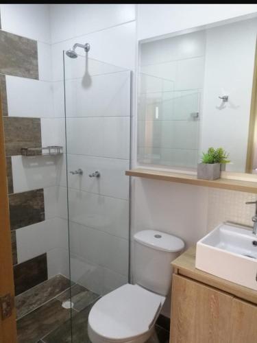 a bathroom with a toilet and a glass shower at HERMOSO y CÓMODO APARTAESTUDIO SABANETA in Sabaneta