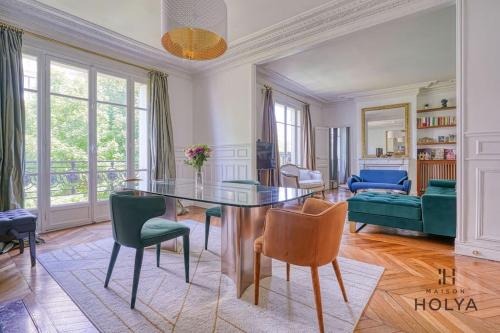 - un salon avec une table en verre et des chaises vertes dans l'établissement Le Royal - À deux pas de Paris - 249C, à Courbevoie