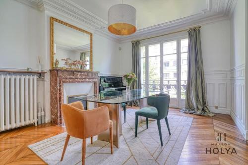 une salle à manger avec une table et des chaises et une cheminée dans l'établissement Le Royal - À deux pas de Paris - 249C, à Courbevoie