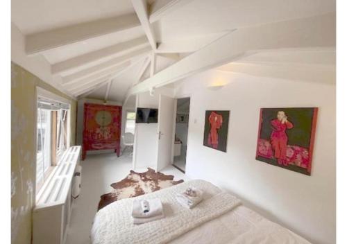 阿姆斯特丹Bed and breakfast private accommodation at Amsterdam Houseboat的卧室配有一张床,墙上挂有绘画作品