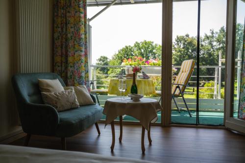 a living room with a couch and a table and a balcony at Haus am Kurpark in Bad Birnbach