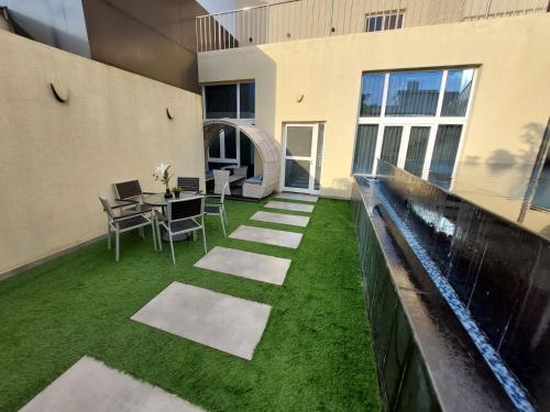 a patio with grass and a table and chairs at Arayik Resort in Taif