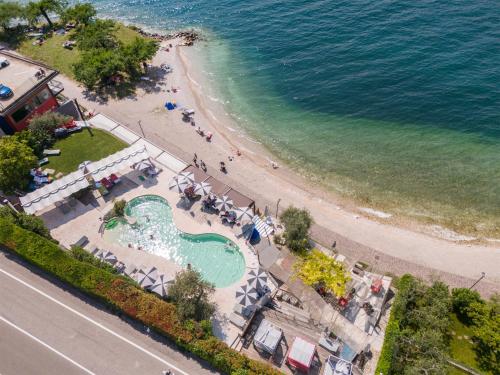 an aerial view of a beach and a swimming pool at Ambienthotel PrimaLuna 3S in Malcesine