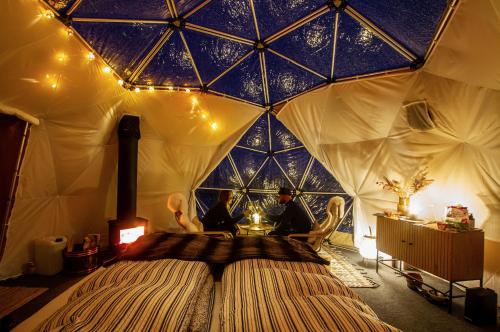 una stanza con una grande tenda con due persone dentro di Handeland Lodge I Arctic Dome a Sauda