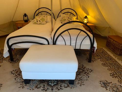 a room with two beds and two ottomans at Glamping Ponsa in Tohkala