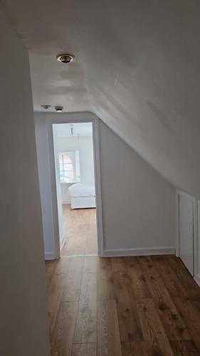 a white room with a hallway with a mirror at The Lodge On The Loch Onich in Onich