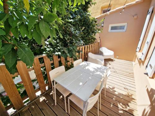 une table et des chaises sur une terrasse en bois dans l'établissement GregBnb - CLIMATISE - T2 Terrasse 38m2 - WiFi, à Toulon