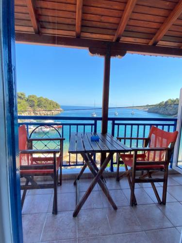 a table and chairs on a balcony with a view of the ocean at Nostos in Patitiri