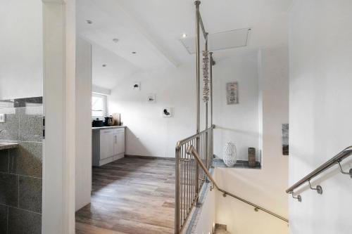 a staircase in a white room with a kitchen at Ferienwohnung Engelsburg in Schwesing