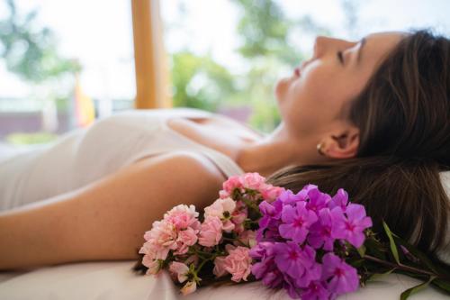 a woman in a white dress laying next to flowers at Haus am Kurpark in Bad Birnbach
