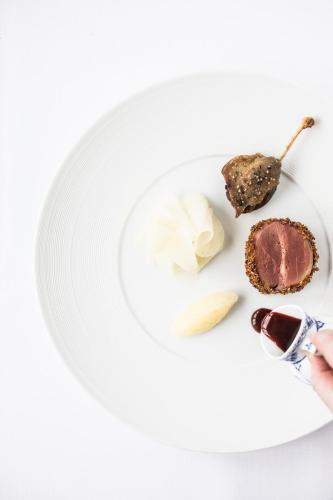 a white plate with a piece of food on it at Dyvig Badehotel in Nordborg