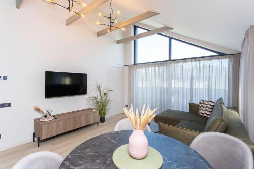 a living room with a table and a couch at LEX apartments in Palanga