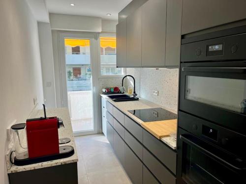une cuisine avec un appareil rouge sur un comptoir dans l'établissement Viva Riviera Large 3 Bedrooms with Balcony, à Cannes