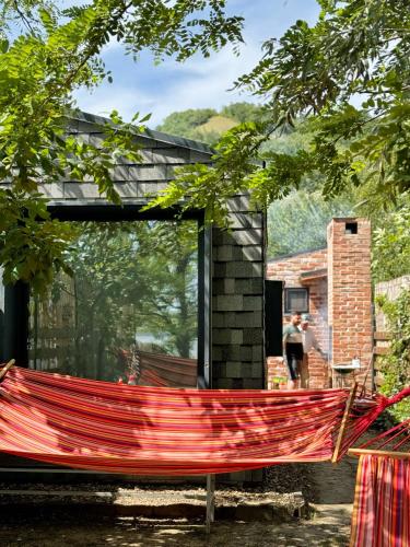 a red hammock in front of a house at Danube Microhouse in Divici