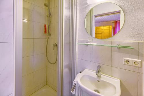 a bathroom with a shower and a sink and a mirror at Hotel Sonne in Staufen im Breisgau