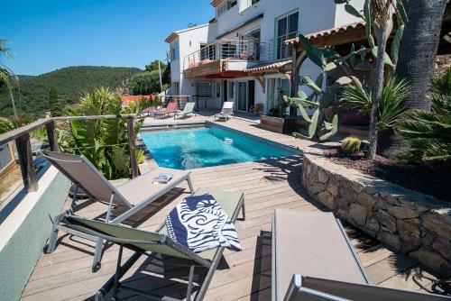 une villa avec une piscine et deux chaises longues dans l'établissement Provence Villa 11 Personnes vue mer Almanarre KiteSurf, à Carqueiranne