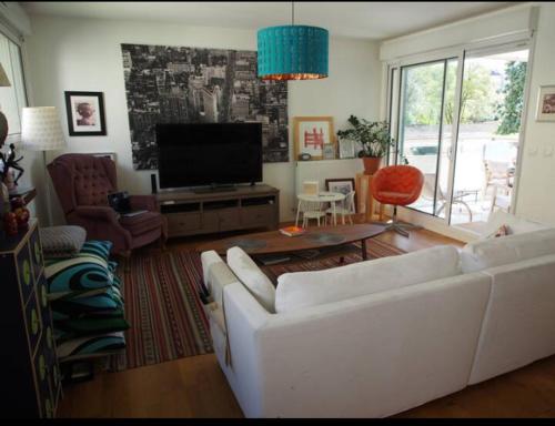 een woonkamer met een witte bank en een tv bij Le bon coin in Bordeaux