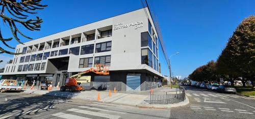 a large white building on a city street with a construction crew at Departamento Centro Plaza 403 in Pitrufquén