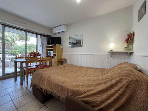 - une chambre avec un lit, une table et une salle à manger dans l'établissement Studio Cabine Climatisé avec Terrasse et Piscine sur le Port de Gruissan, Proche Plage - 4 Couchages - FR-1-229-104, à Gruissan