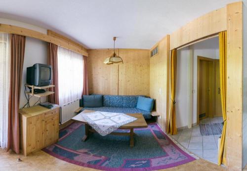 a living room with a blue couch and a tv at Haus Charlotte in Kals am Großglockner