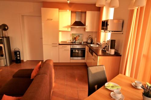 a living room with a couch and a kitchen at Meerblick 5 - Großenbrode in Grossenbrode