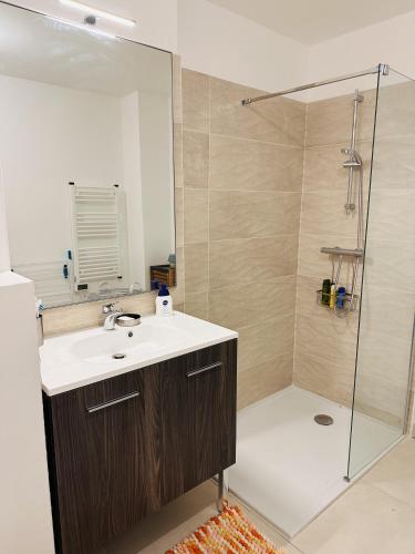 une salle de bain avec un lavabo et une douche dans l'établissement L'échappée, à Bandol