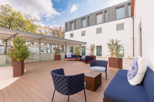 an outdoor patio with furniture and a building at Palácio do Governador - Lisbon Hotel & Spa in Lisbon