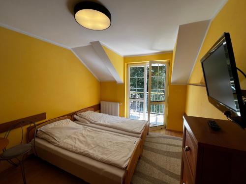 una camera da letto con un letto e una TV a schermo piatto di Nadmorskie Pokoje i Apartamenty a Krynica Morska