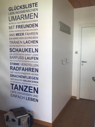 a bathroom with a wall with a sign on it at "Sonne auf der Haut" - Residenz Glücksmomente 1OG in Langeoog