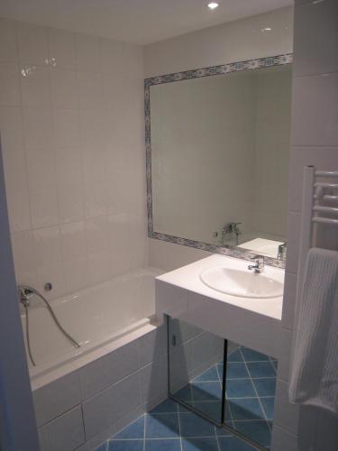 une salle de bain avec une baignoire, un lavabo et un miroir dans l'établissement Beachside apartment with sea view, à Antibes
