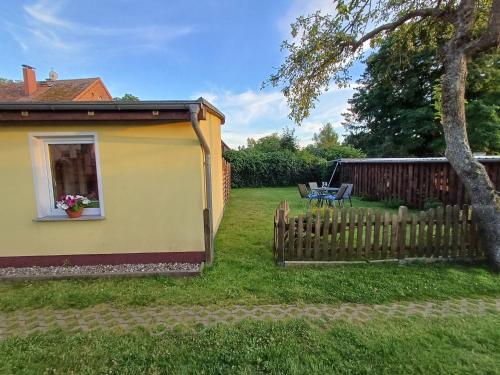 einen Hinterhof mit einem Zaun und einem Haus in der Unterkunft Ferienbungalow Jahnke auf Usedom mit Wlan in Zirchow