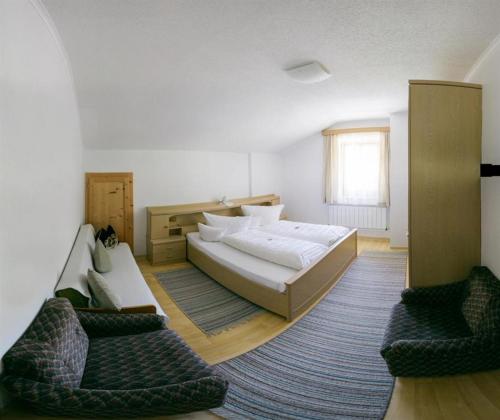 a bedroom with a large bed and two chairs at Haus Charlotte in Kals am Großglockner